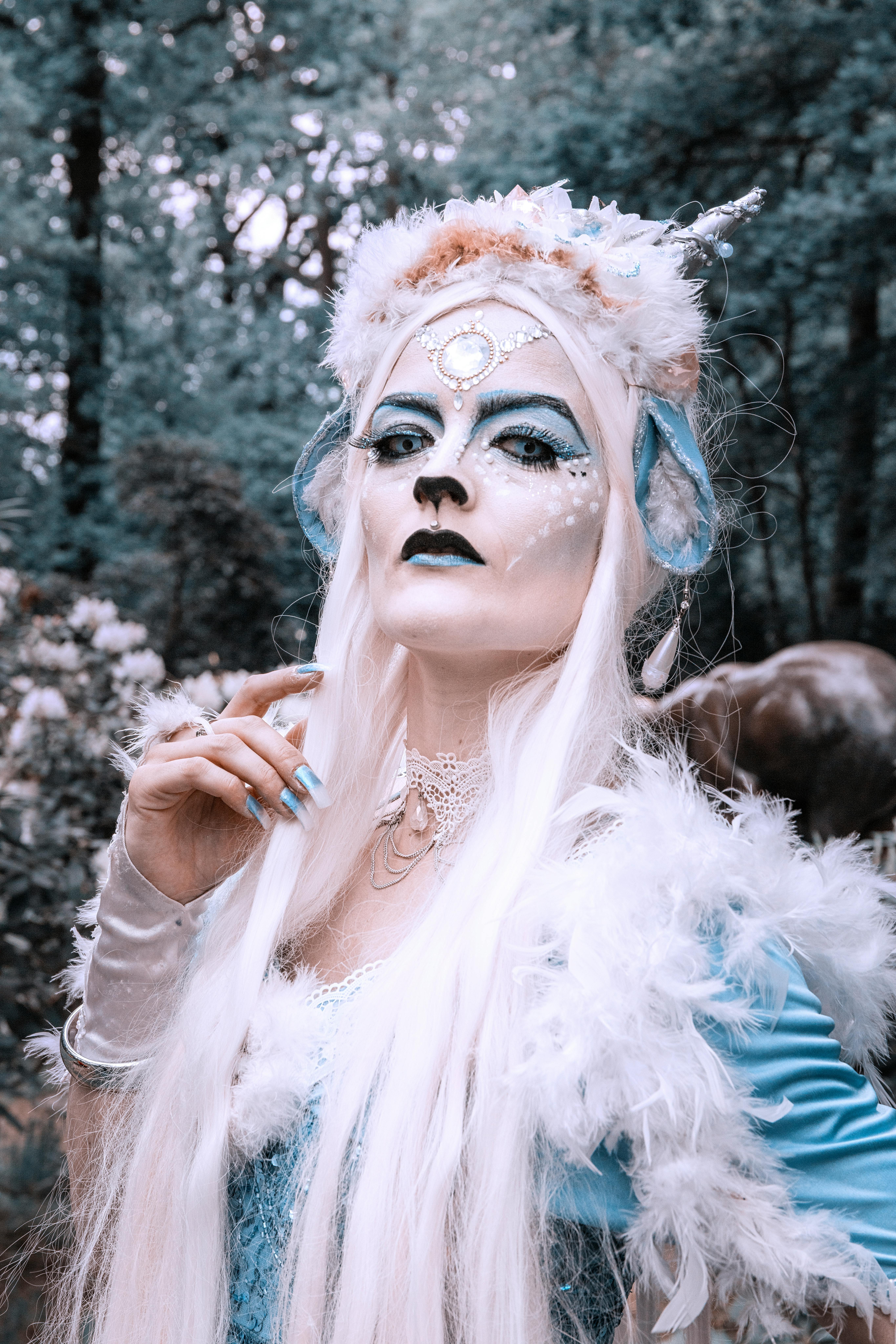 Enchanting fantasy character with ornate feathered costume and expressive makeup.