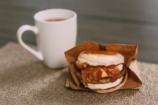 Delicious breakfast sandwich with bacon, cheese, and coffee for perfect morning start.