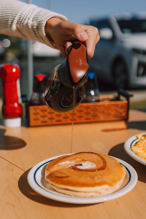 Free A Person Pouring Syrup on Pancakes Stock Photo