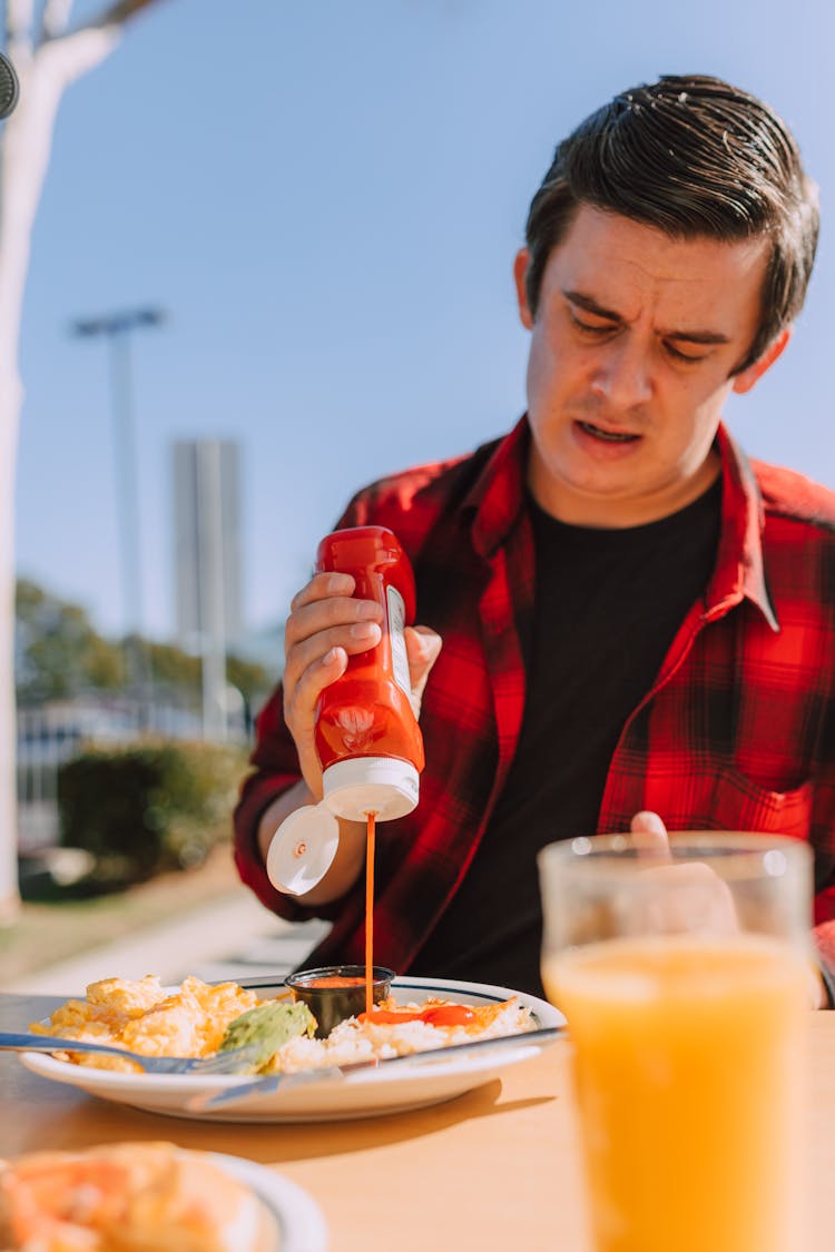 Man Pouring Ketchup On His Breakfast