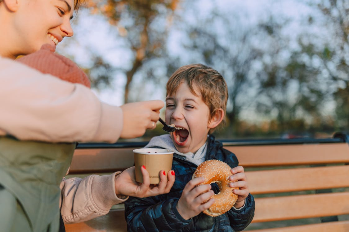 Woman Feeding Kid a Bowl of Ice Cream