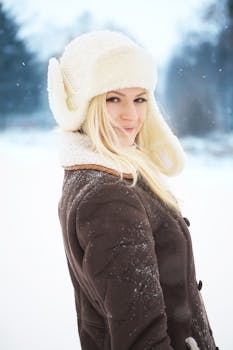 Beautiful woman posing in winter clothing outdoors, showcasing cozy and chic style.