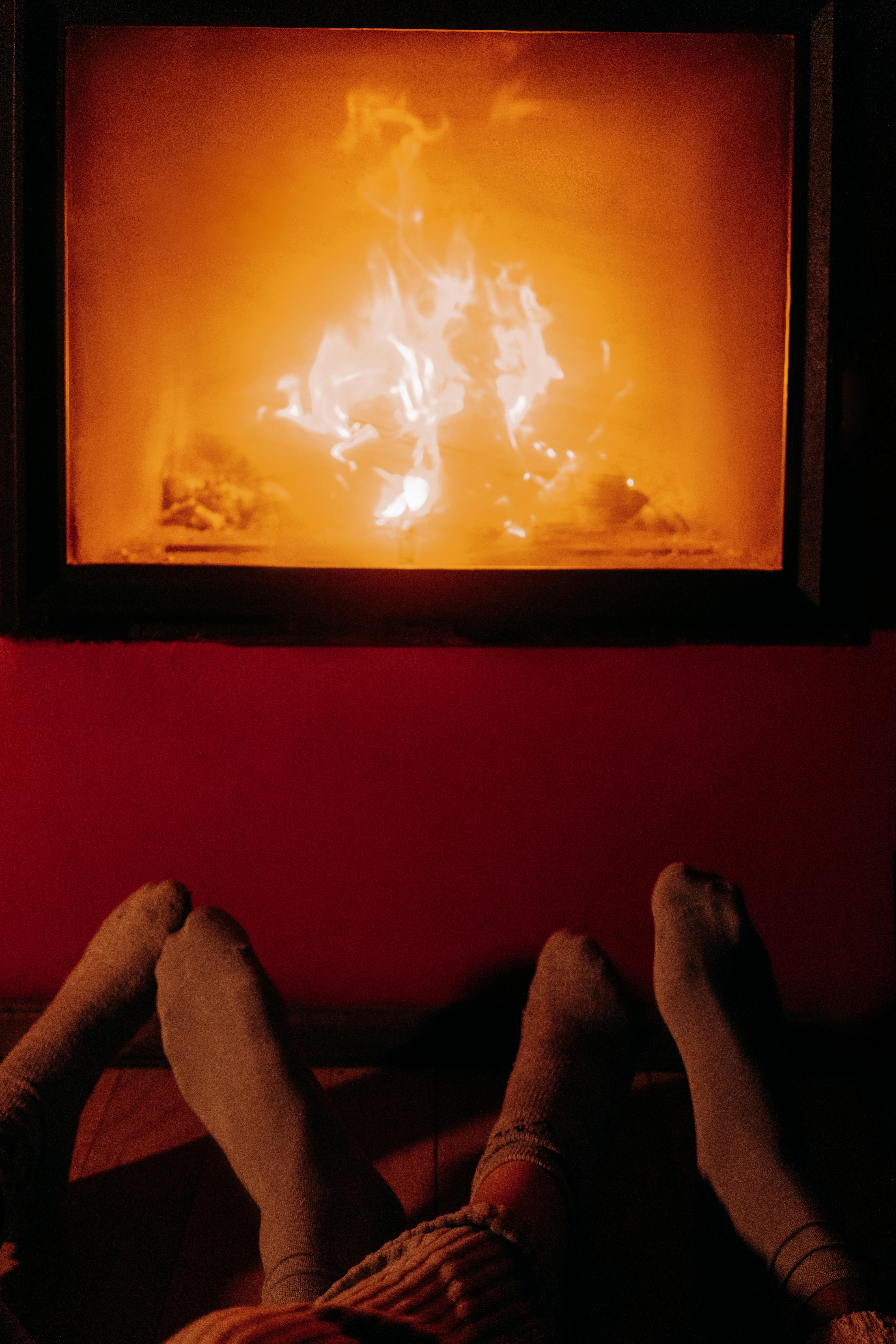 couples warming feet next to fireplace