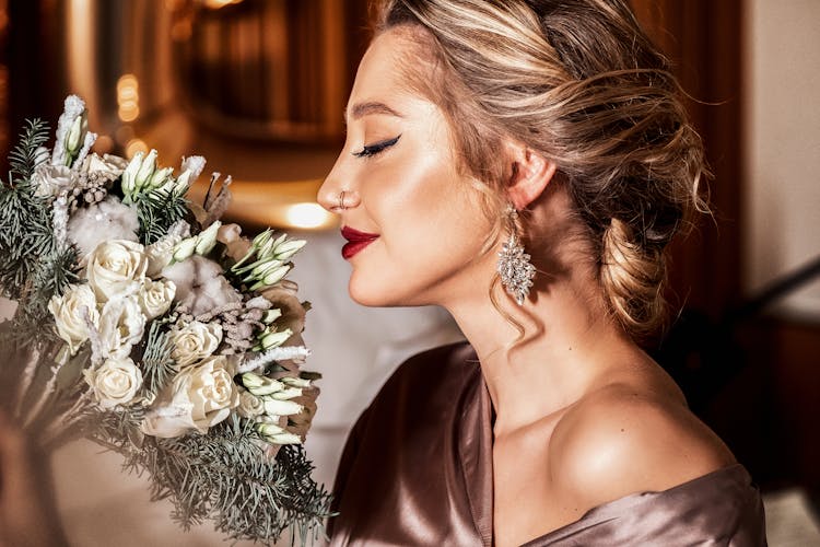 Woman Smelling A Bouquet Of Flowers