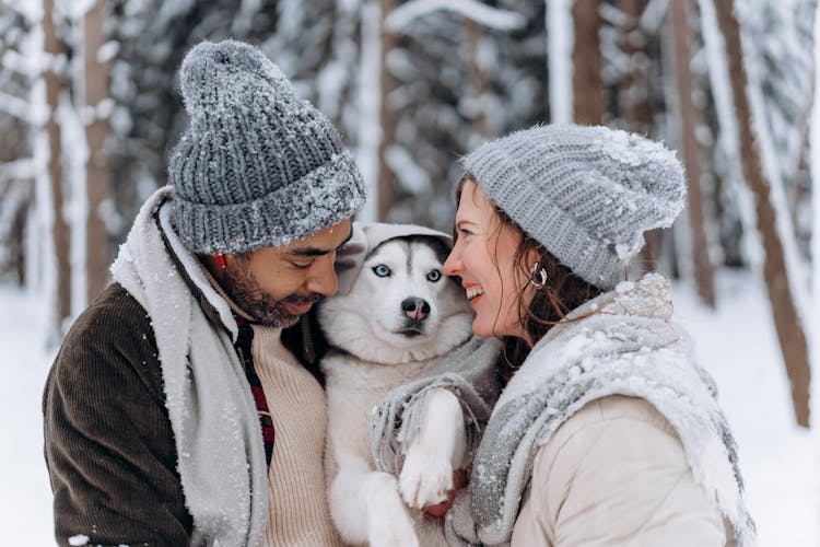 Man And Woman Hugging A Dog