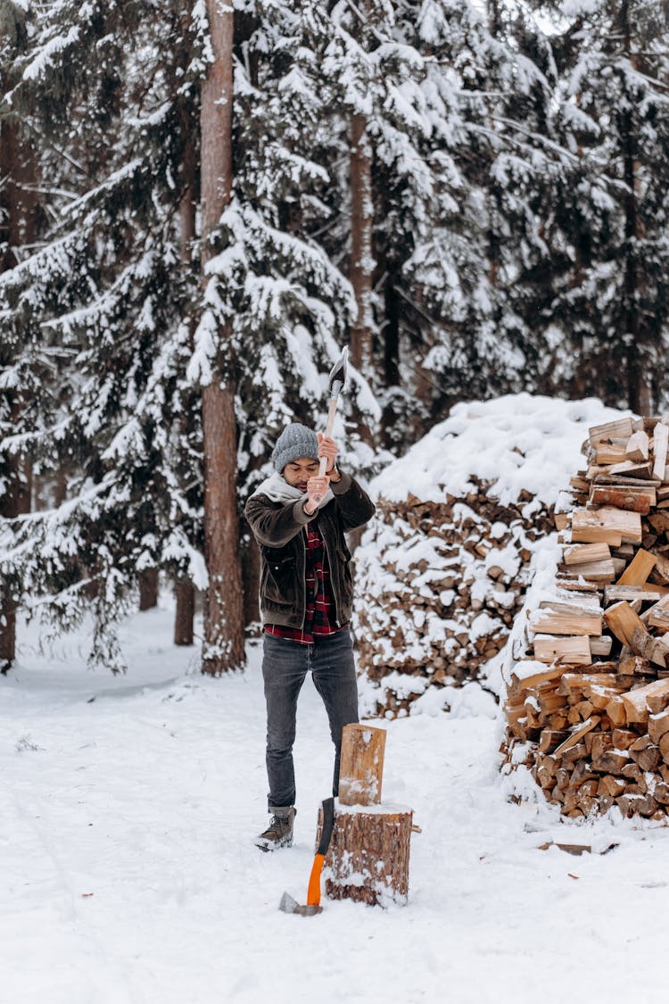 A Man Chopping Wood In A Winter Forest