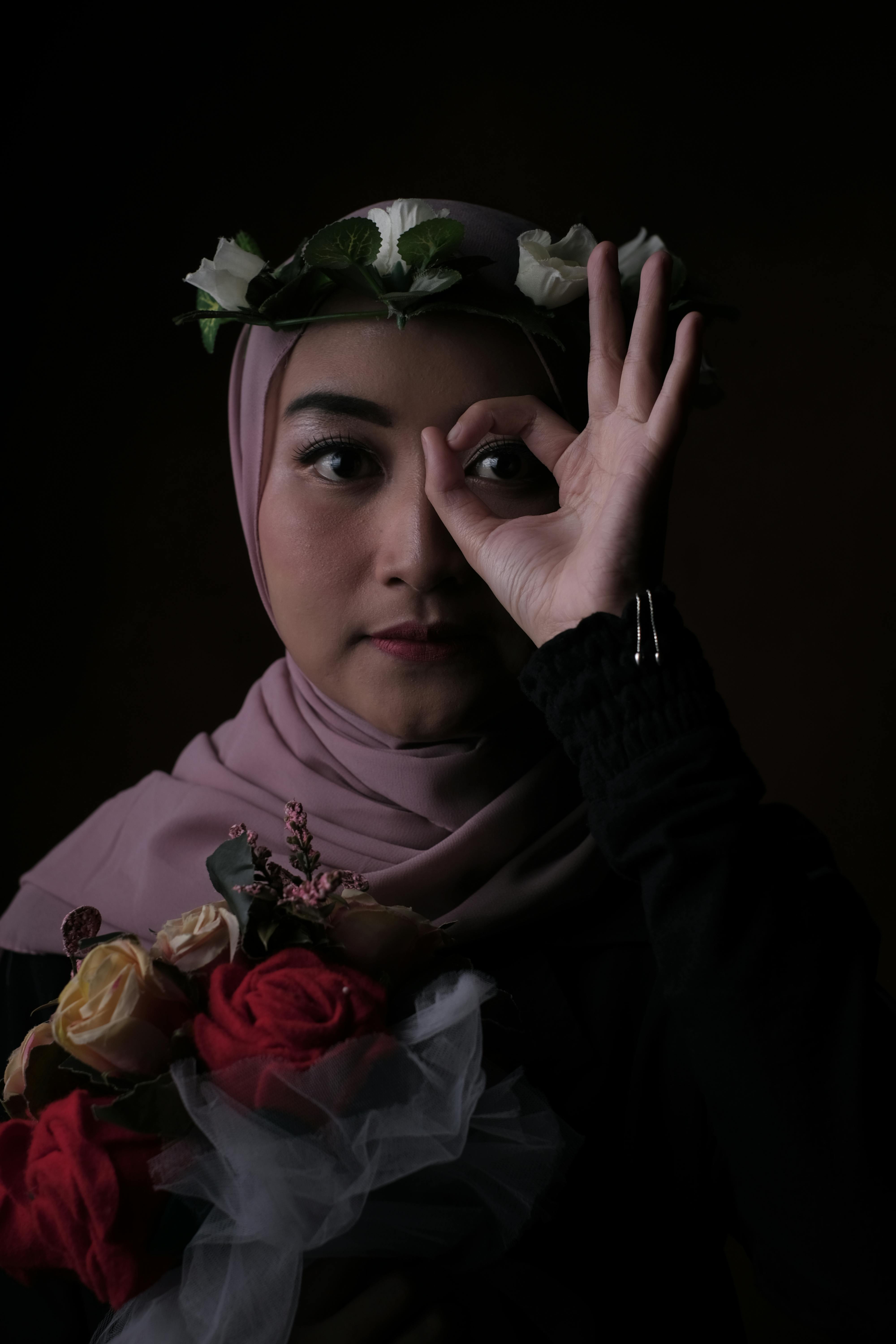 stylish young asian woman in hijab showing ok sign in studio