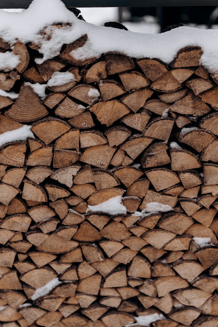 Close Up Of Stacked Firewood Covered In Snow 