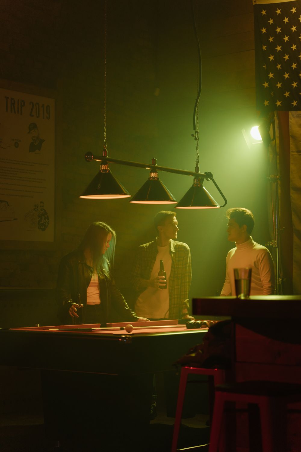 Friends socializing and playing pool inside a sports bar