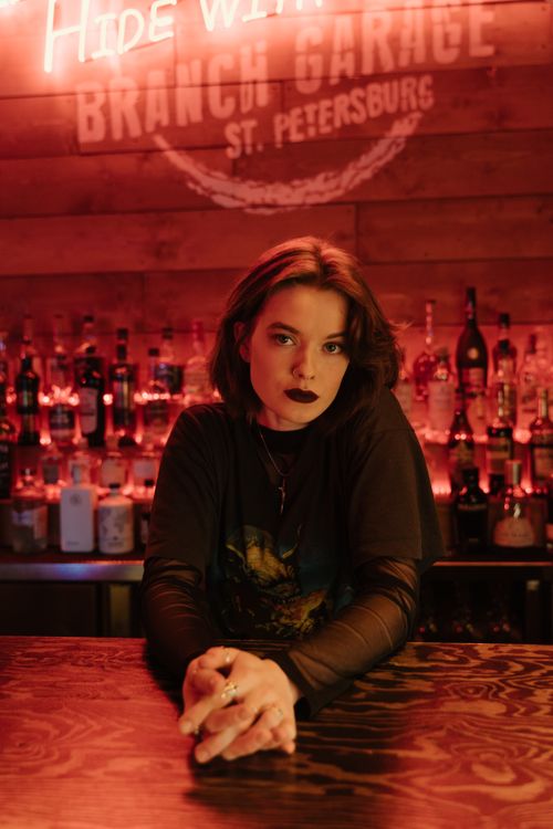 Free A captivating portrait of a woman with dark lipstick at a trendy bar counter under warm lighting. Stock Photo