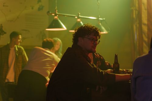 Free Friends enjoying drinks and conversation at a cozy bar. Stock Photo