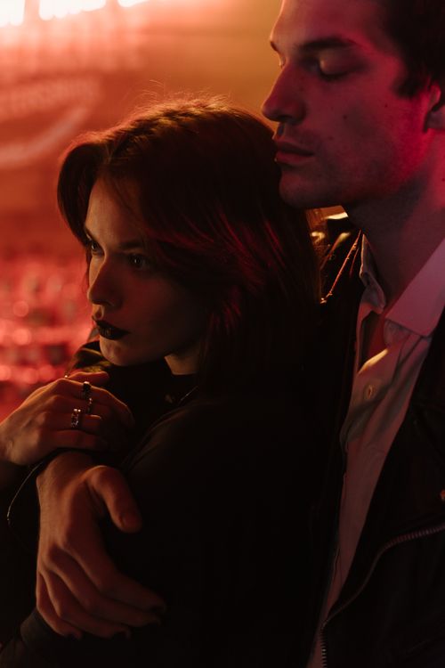 Free A romantic couple stands closely embraced in warm, ambient lighting, reflecting intimate connection and love. Stock Photo