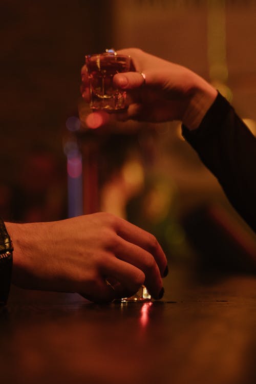 Person Holding a Shot Glass