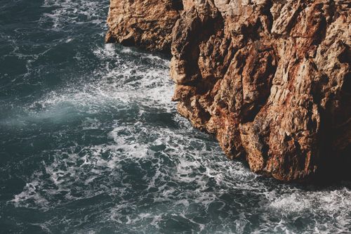 Free Dramatic cliffs and waves in a serene coastal setting. Stock Photo