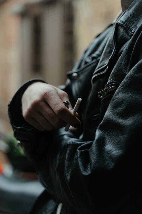 Free Person in Black Jacket Holding a Cigarette  Stock Photo