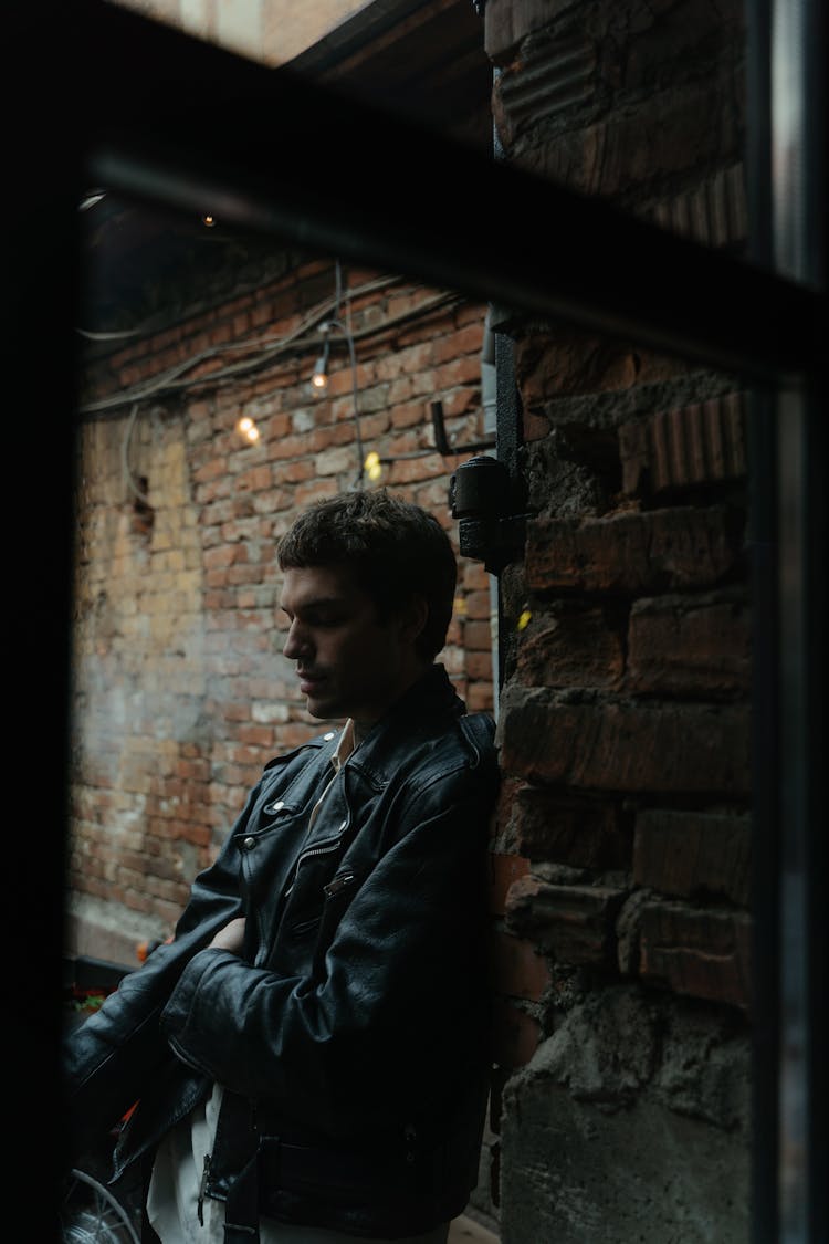 A Man Smoking Near A Window