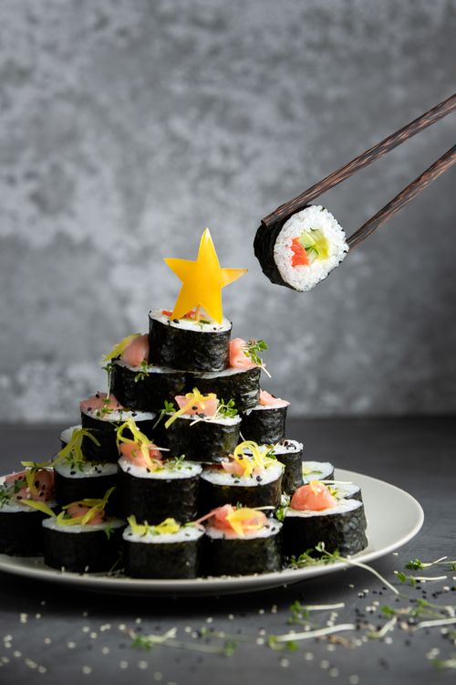 Free Artistic sushi rolls arranged as a pyramid with a star garnish, perfect for culinary inspiration. Stock Photo