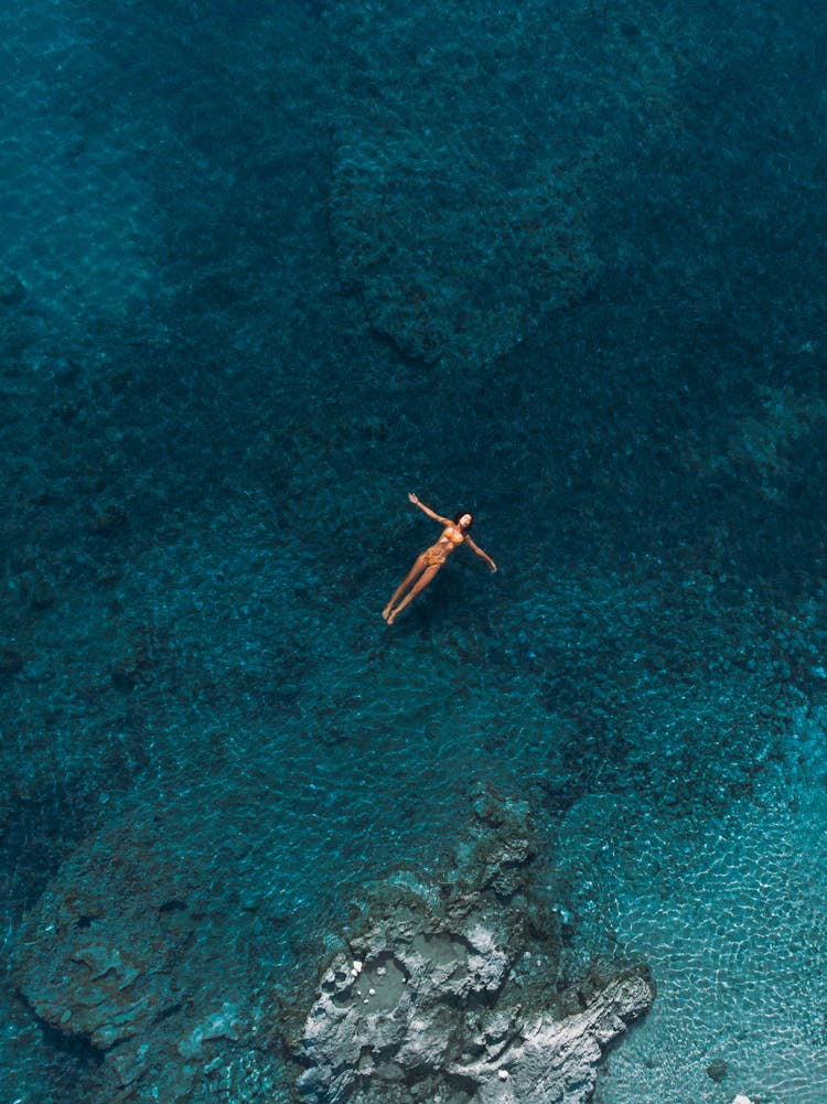 A Woman Floating On The Sea Surface