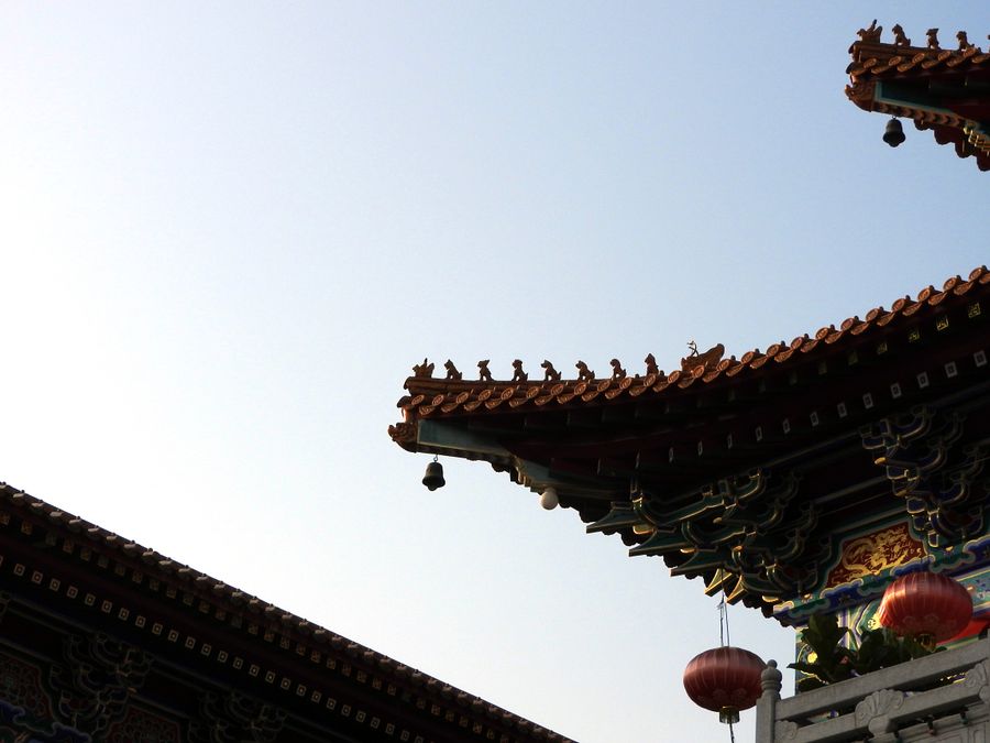 Intricate Chinese temple roof against a blue sky