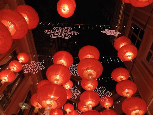 Free Chinese lanterns with garlands hanging between buildings in street Stock Photo