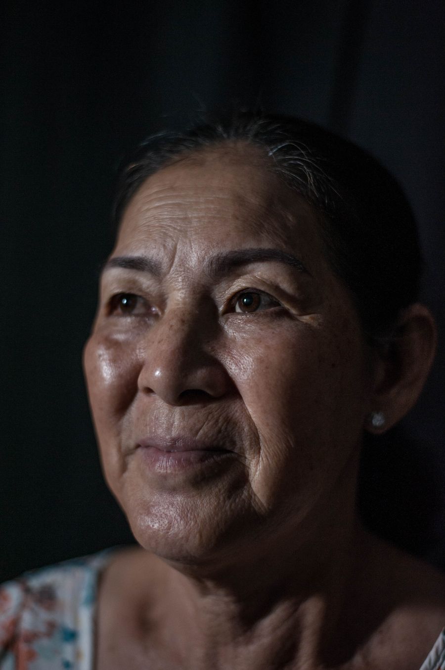 Close portrait of an elderly woman gazing upward with quiet thoughtfulness