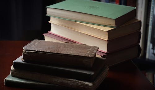 Stacked Up Books on Wooden Table