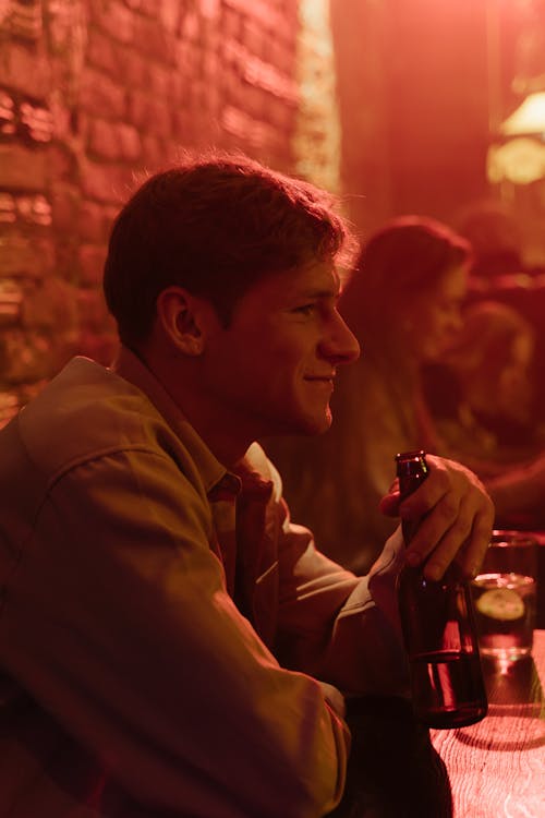 Smiling Man Drinking Beer in a Bar