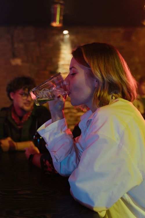 Free A group of young adults enjoying drinks in a dimly lit bar, perfect nightlife vibe. Stock Photo