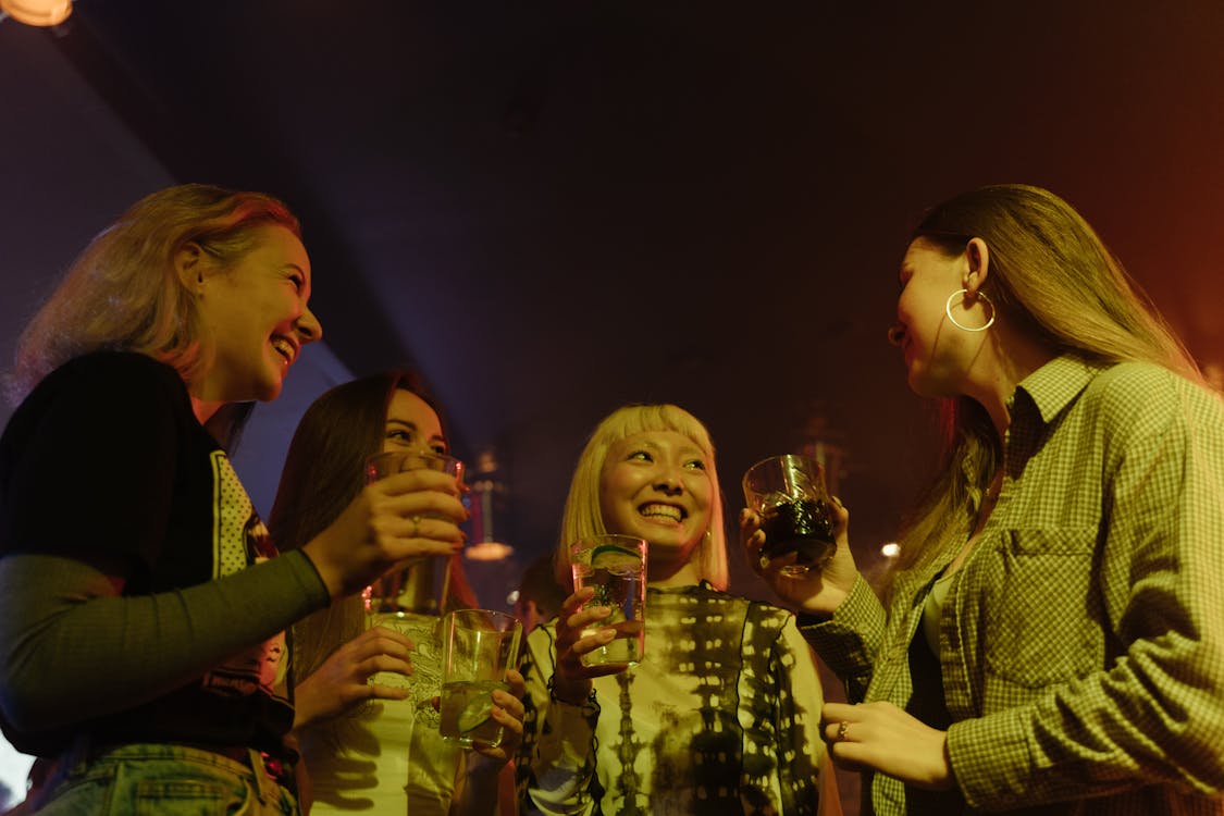 Free A joyful group of friends celebrate and enjoy drinks at a lively nightclub. Stock Photo