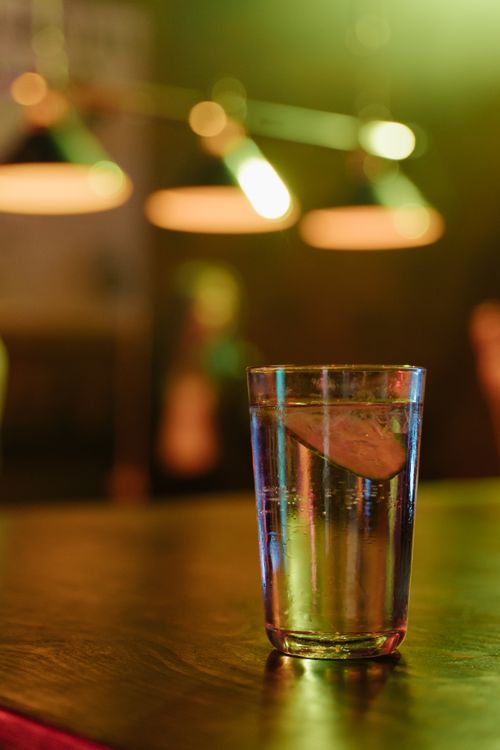 Free A tall glass of lime soda with ice in a cozy cafe ambiance. Stock Photo