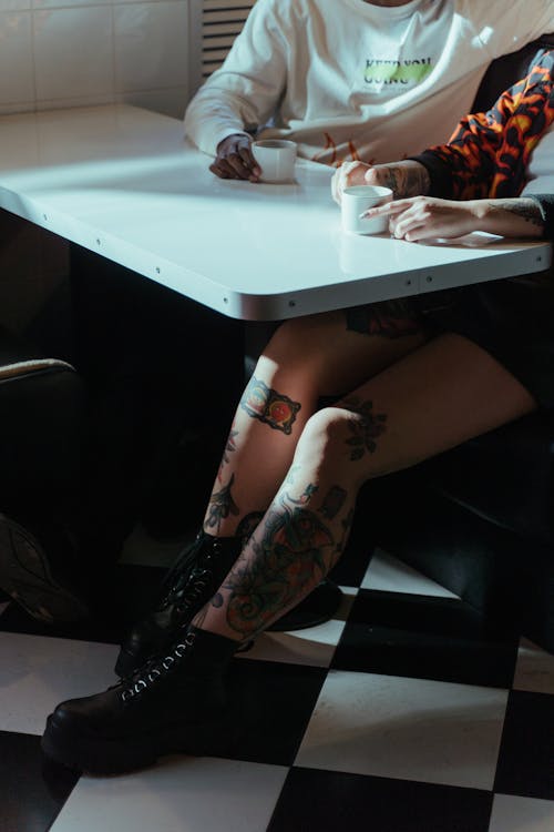 Photo of A Tattooed Woman and A Man Having Coffee Together