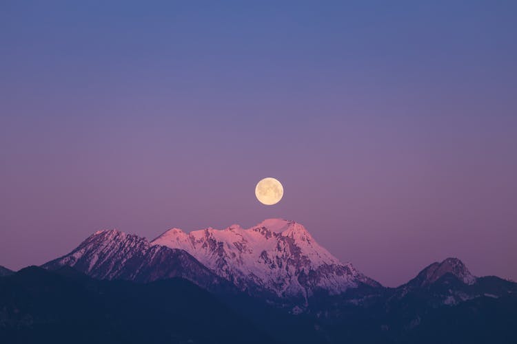 Full Moon Over Snow Covered Mountain