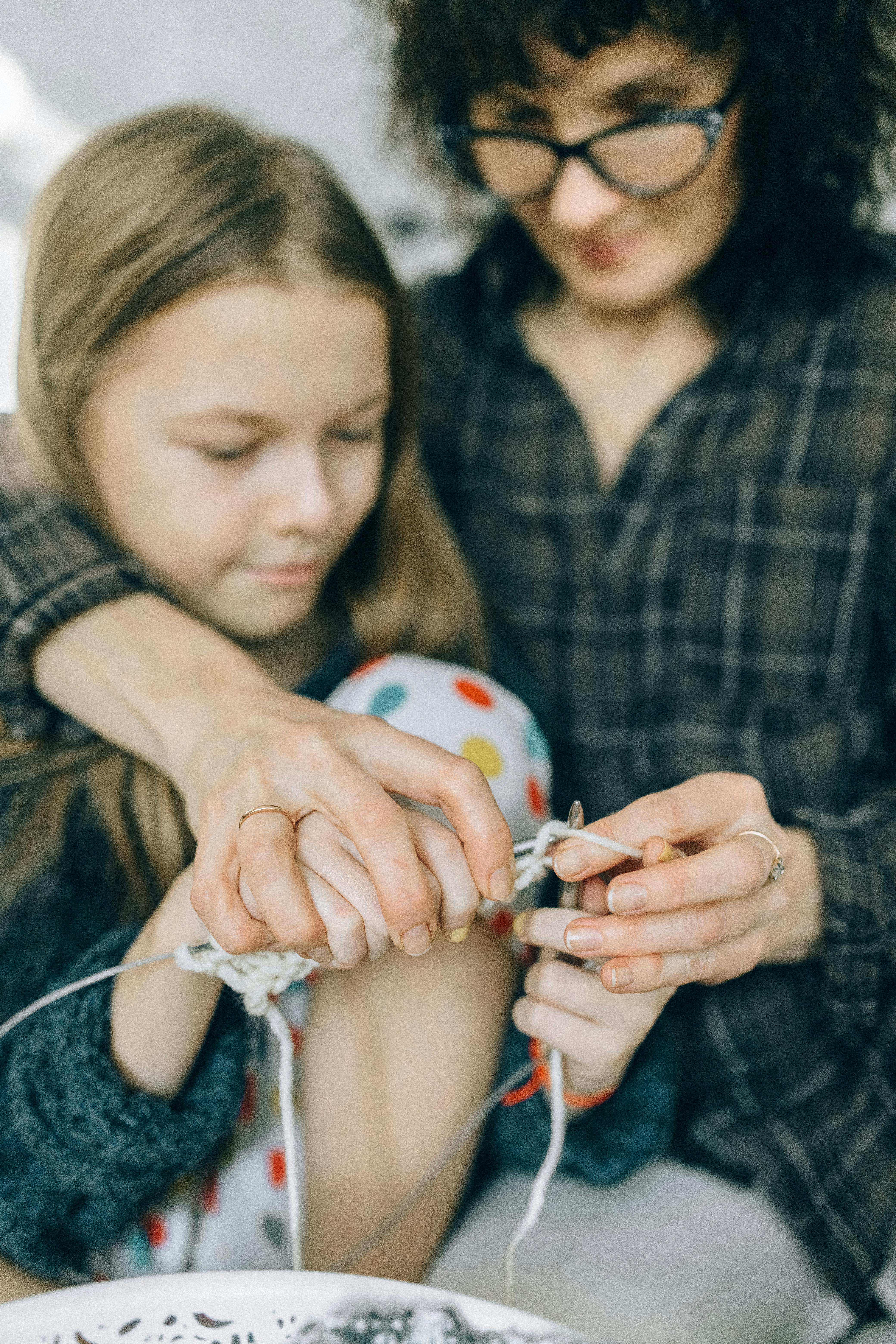 mother teaching her daughter knitting