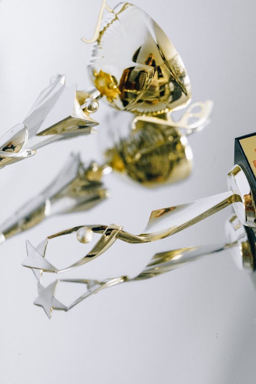 Gold and Silver Trophy on White Table