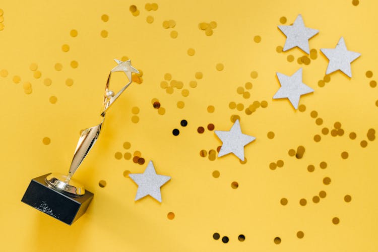 Golden Statuette And Stars On Yellow Background