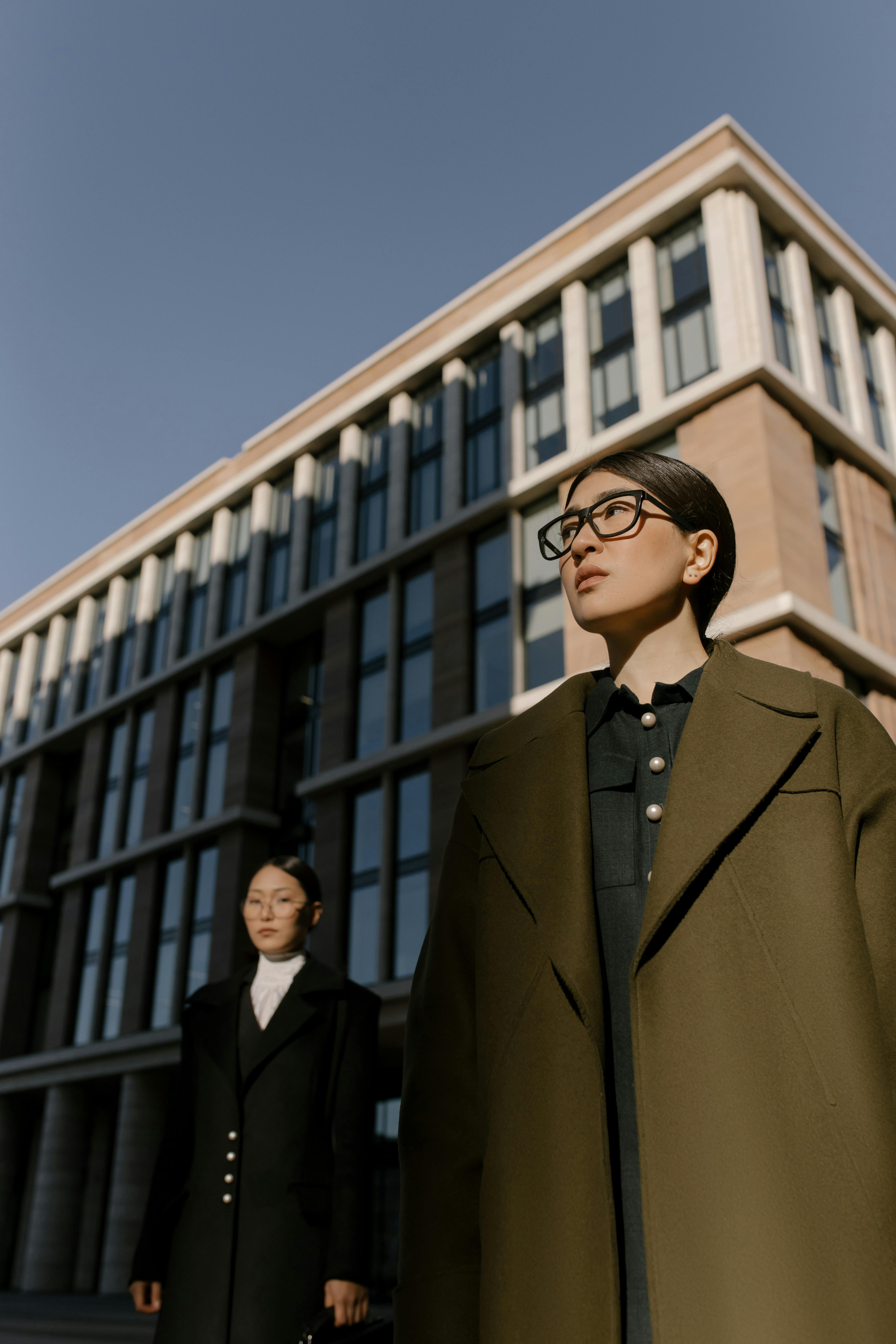 woman in brown coat standing near building