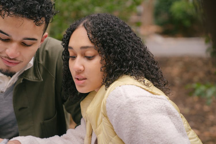 Concentrated Latin American Couple In Park