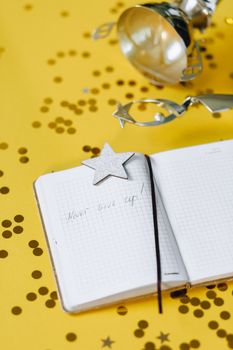 Open notebook with 'Never give up!' on yellow background, star decor, trophy.