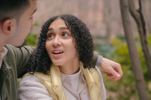 Hispanic couple hugging and looking at each other in park