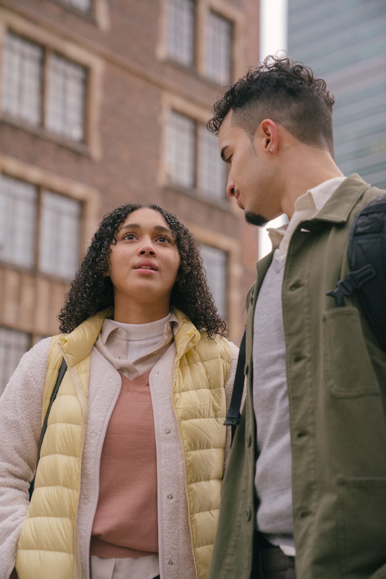 Latin American Couple Standing On City Street Near Buildings