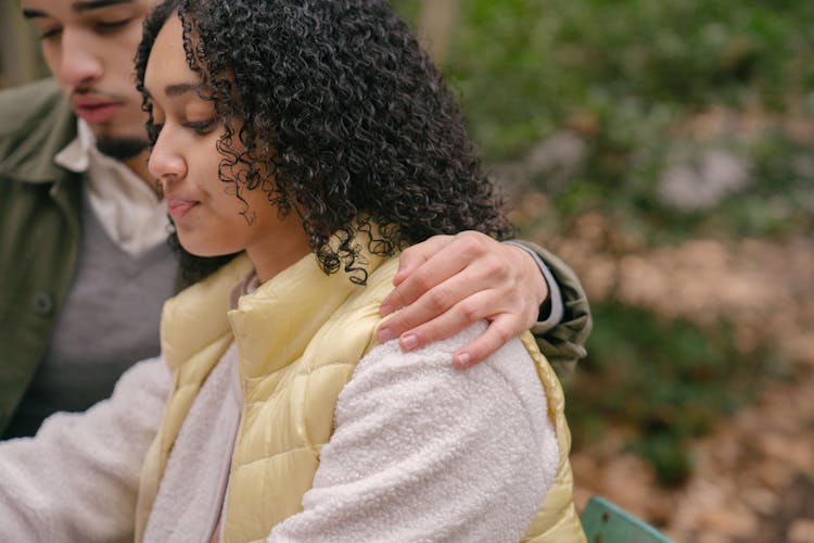 Focused Hispanic Couple Embracing In Park