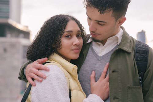 Loving tender Hispanic couple embracing on urban street