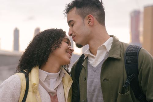 Free Romantic Hispanic couple in casual clothes standing with closed eyes while spending time together on street in city in daylight Stock Photo