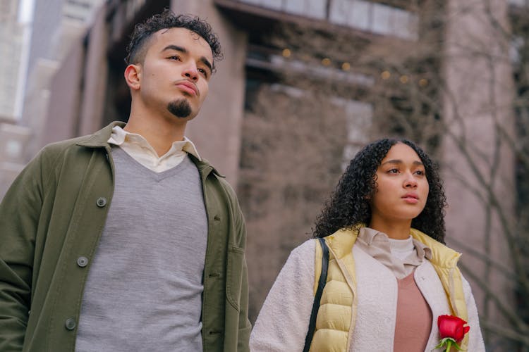 Hispanic Couple Standing On Street And Looking Forward