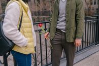Crop anonymous man with red rose standing with girlfriend on street