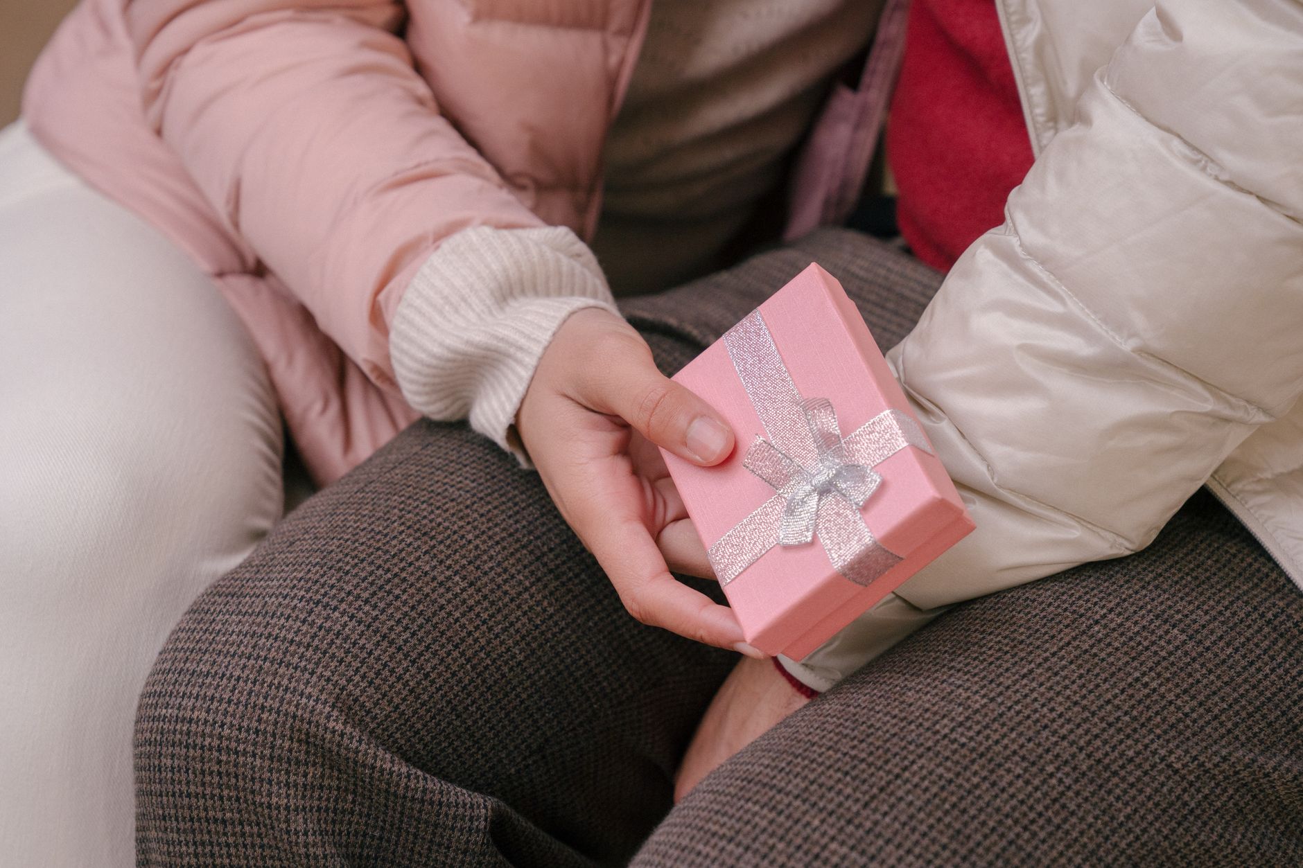 High angle of crop anonymous girlfriend with present box given from boyfriend for occasion
