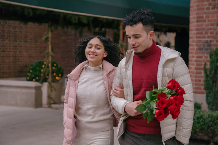 Romantic Hispanic Couple Walking On Street And Looking Away In Daytime