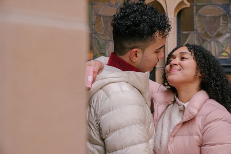 Happy Hispanic Couple Hugging On Street