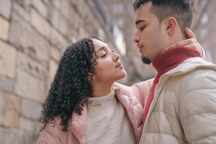 Loving Hispanic Couple Hugging On Street