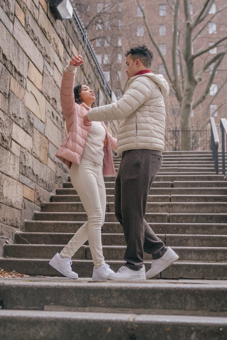 Active Hispanic Couple Dancing On Stairs